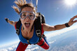 A woman skydiving screams in excitement as she experience a thrilling adrenalin rush free falling at high speeds through the skies. An adventurous thrill seeker loving the feel of flying in the air.