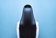 Elegance in simplicity: long silky brown hair on a bright blue background