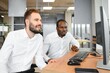 © Serhii - Two diverse colleagues traders talking to each other, sitting in the office in front of multiple computer screens. Stock trading, people, business concept