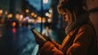 Young woman using mobile phone in the city at night. Blurred background