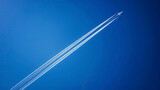 Fototapeta Natura - airplane tracks in the air, blue sky background, plane tracks in the sky