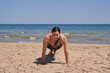 © AntonioJose - Healthy woman in sportswear doing a plank on the beach