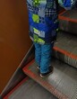 Child walking up the escalator in a metro station, close-up
