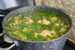 Cooking meat broth with herbs in a saucepan