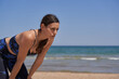 © AntonioJose - Exhausted healthy woman in sportswear resting on the beach