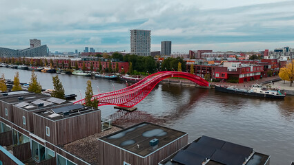 Wall Mural - Aerial drone view of modern footbridge Python Bridge at Eastern Docklands neighborhood of Amsterdam Netherlands