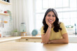© Prostock-studio - Woman smiling at kitchen counter at home