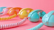 © Jane_S - A set of colorful vintage phone handsets on a pastel pink background, in a minimal concept.