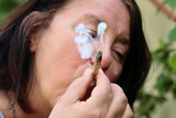 Fototapeta  - Eine Frau raucht einen Joint