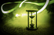Hourglass as time passing concept for business deadline, urgency and running out of time. Sandglass, egg timer on dark background showing the last second or last minute or time out.