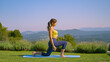 Outdoor yoga workout in an idyllic green garden with a stunning view over valley