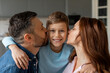 © Prostock-studio - Happy family moment with parents kissing child