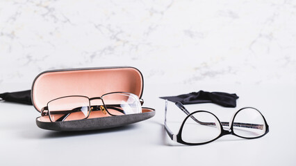 Wall Mural - Eyeglasses in an open hard case and eyeglasses on a table