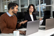 © zinkevych - Handsome young businessman and beautiful business woman in headsets using laptops