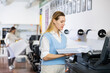 Technician operator changes paper on large printer plotter machine