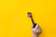 The hand of a young man holds a smoking pipe on a background of yellow paper. Mouth and lips in a ragged hole. Concept of bad habit and ancient way of smoking tobacco.