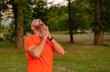 A sporty man is doing stretching exercises before running or workout outdoor in the summer park active healthy lifestyle. 