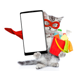 Poster - Cute kitten wearing superhero costume holds bucket with washing fluids and shows  big smartphone with white blank screen in it paw, showing close to camera. Isolated on white background