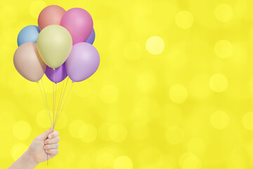 Aufkleber - Female hand holds bunch of colorful balloons on yellow blurred background. Empty space for text