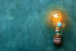 A simple image featuring a bright light bulb held in a hand against a wall background, showcasing a concept of creativity, innovation, and inspiration with a focus on energy and ideas