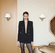 fashionable brown hair woman in black blazer in luxury hotel interior, quiet luxury