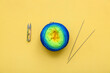 Knitting needles, yarn ball and knitting needles on yellow background