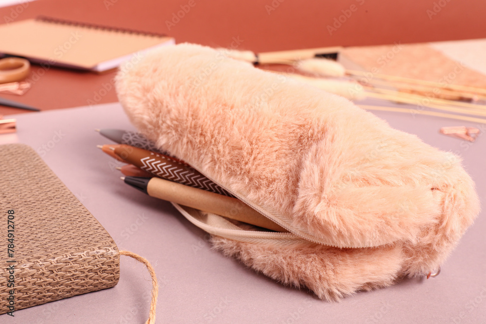 Pencil case with pens on colorful background