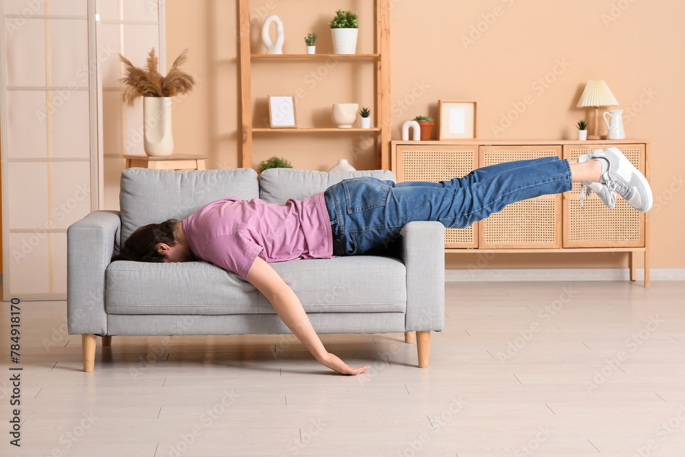 Weary young man lying on sofa at home