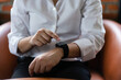Hands of businessman checking time on smartwatch for deadline work and sitting on comfortable couch