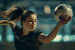 © alesia0604 - Focused female Athlete playing handball or volleyball in indoor court with blurred sport field background