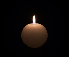 Wall Mural - Single round candle burning in the dark