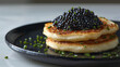 Blini topped with a generous spoonful of caviar, a luxurious and rich gourmet dish.