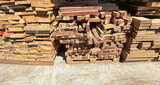 Fototapeta  - Lumber planks stack in the sawmill.  Stacked of woods on ground in furniture factory