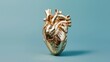 An artistic golden heart sculpture displayed against a tranquil blue background, symbolizing love and life.