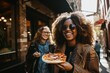 Happy young female friends having fun and eating delicious pizza in the vibrant city atmosphere