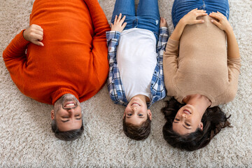 Poster - Happy family father, mother and cute son boy lying on floor