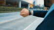 Closeup of professional businessman hand show smart watch and pointing the times. Professional boss, ceo, leader checking time from top view with city view. Business. Blurred background. Exultant.