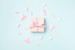 Pink gift or present on blue background top view. Birthday, Woman or Mothers Day greeting card.