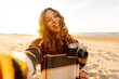 Selfie time. Young woman posing by the sea at sunset. Travel blog. Adventure, vacation concept.