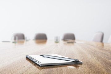 Poster - Close up of wooden conference table with empty notepad and pen for morning notes. Blurry chairs in the backdrop. Business meeting concept. Mock up place, 3D Rendering.