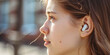Close-up young woman ear with a wireless earpiece. Bluetooth wireless headphone technologies. 