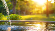 Sunlit Water Stream from Pipe. Water flowing from a pipe with sunlight filtering through trees in a blurred background