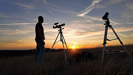Wall Mural - amateur astronomer observing solar eclipse and sun with a telescope and special solar filter.