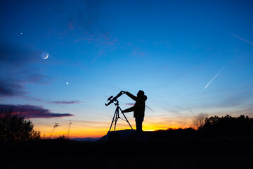 Wall Mural - amateur astronomer looking at the evening skies, observing planets, stars, moon and other celestial 