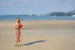 Young beautiful woman holding bouquet on tropical beach in Thailand