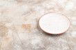 Empty white ceramic plate on brown concrete. Side view, copy space