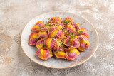 Fototapeta Desenie - Rainbow colored dumplings with microgreen on brown concrete. Side view