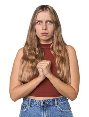 Wall Mural - Studio portrait of a blonde Caucasian woman scared and afraid.