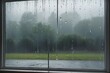 AI generated illustration of raindrops falling from a window on a gloomy day