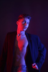 Poster - Sexy young man on dark background in neon lights